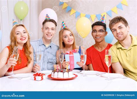 Young People Celebrating A Birthday Sitting At The Stock Photo Image