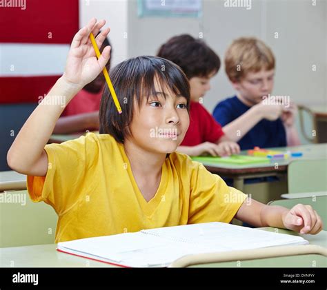 Japanese Elementary School Student Raising His Hand In Class Stock