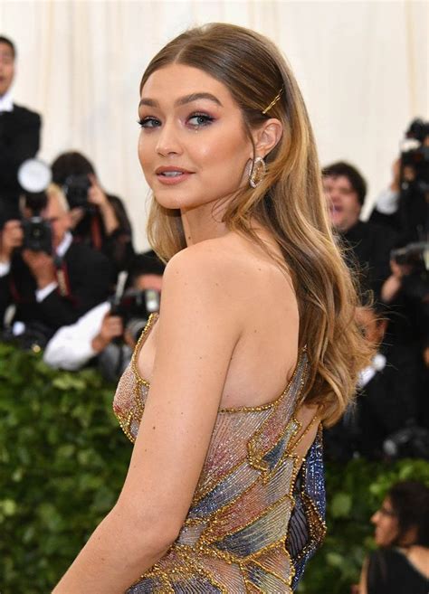 gigi hadid at the 2018 met gala with long sleek center parted hair secured with bobby pins and