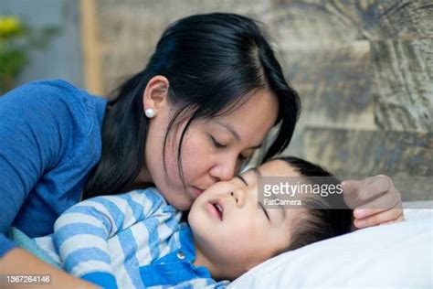 Woman Kissing Child Goodnight Photos And Premium High Res Pictures