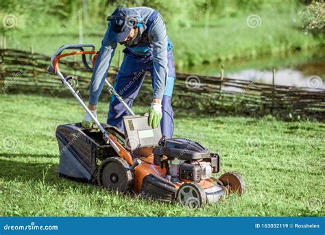 Gardener Working With Lawn Mower On The Backyard Stock Image Image Of