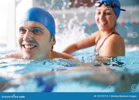 Female Swimming Teacher Giving Man One To One Lesson In Pool Stock Image Image Of Class
