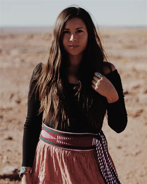 A Woman Standing In The Desert With Her Hand On Her Hip