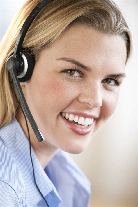 A Young Woman Wearing A Headset Is Smiling At The Camera