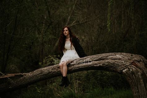 Ginger Girl Posing On Bending Over Ground Tree Branch And Looking At