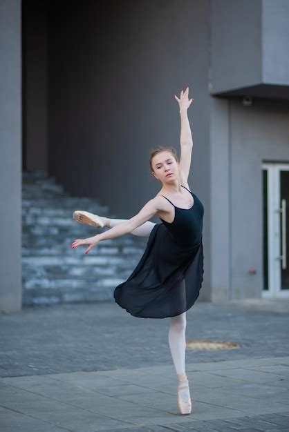 premium photo ballerina in a tutu posing against the backdrop of a residential building