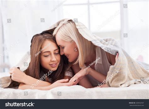Attractive Young Lesbian Couple Is Lying In Bed Under Blanket They Are