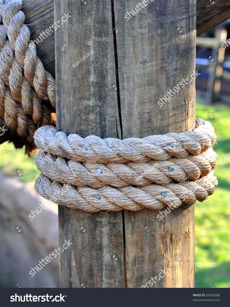 Three Layers Of Rope Tied Around A Wooden Log In The Shade On A Sunny