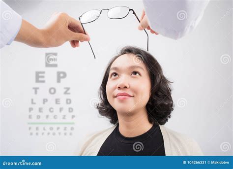 new glasses optometrist giving asian woman eyeglasses to try stock image image of medical