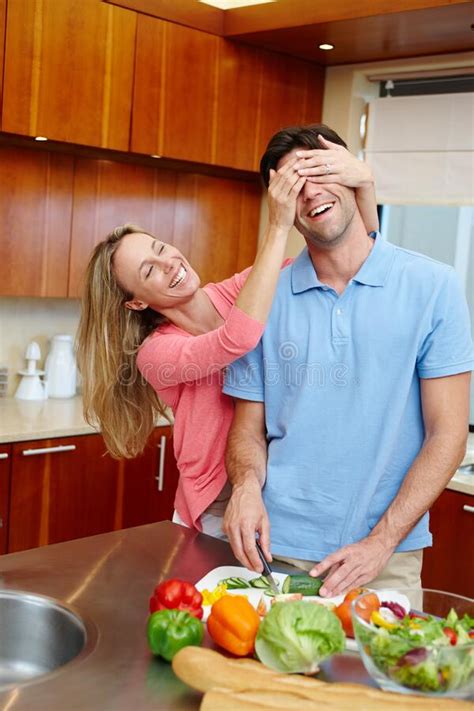 guess who a loving married couple being playful while preparing food in the kitchen stock