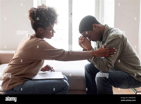 Black Woman Psychologist Comforting Upset Man Patient Side View Stock