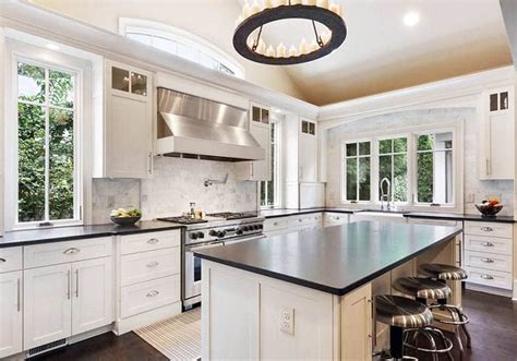 I like the black stone in the backsplash. White Kitchen Cabinets with Dark Countertops - Designing Idea