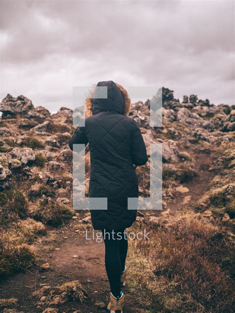 A Woman Hiking Up A Rugged Mountainside — Photo — Lightstock
