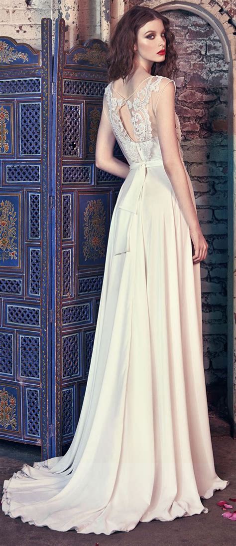 A Woman Standing In Front Of A Wooden Door Wearing A White Dress With