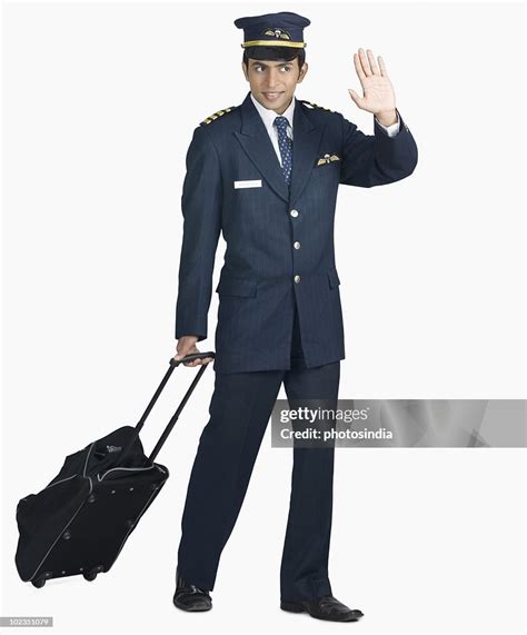Pilot Carrying His Luggage And Waving His Hand High Res Stock Photo