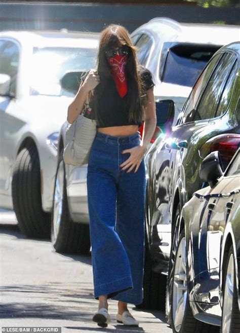 Dakota Johnson Flashes Her Midriff In A Dark Crop Top And High Waisted Denim Bell Bottoms