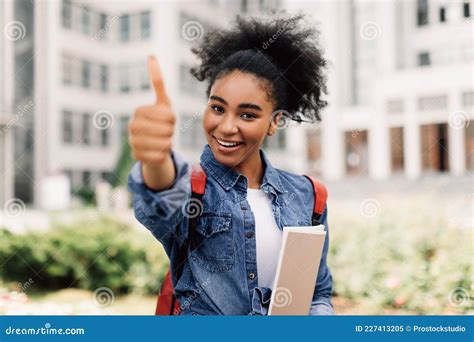 Happy Black Student Girl Gesturing Thumbs Up Near University Building
