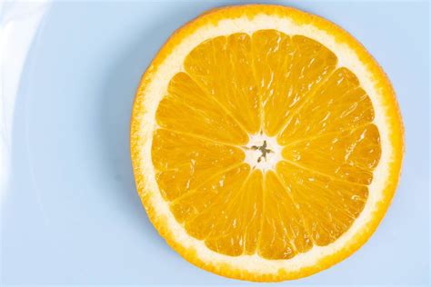 Hand Holds Orange Fruit Above Blue Background Creative Commons Bilder