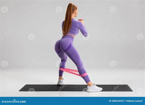 Fitness Woman Doing Exercise For Glutes With Resistance Band On Gray Background Athletic Girl