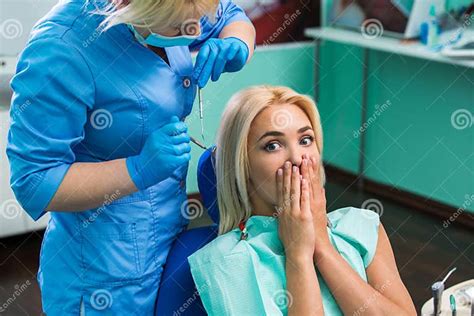 girl frightened by dentist covers her mouth the girl is afraid of the dentist stock image