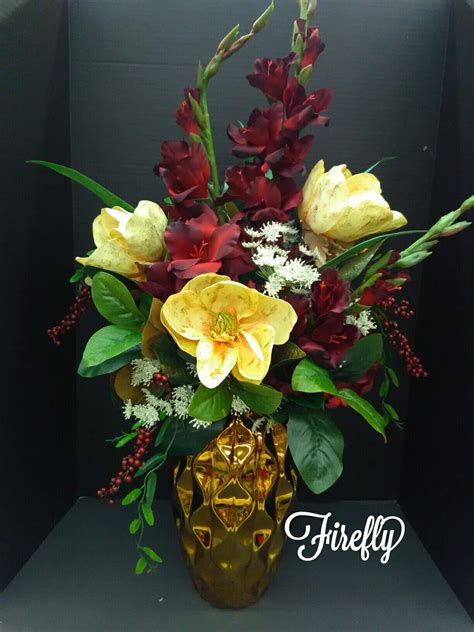 This elegant silk floral arrangement in deep contrasting color makes a statement with its grande size. Magnolia and burgundy gladiola floral arrangement (With ...