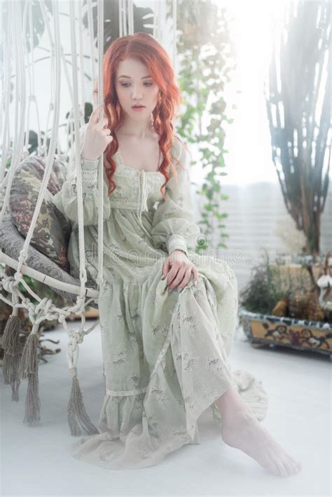 Tender Portrait Of A Young Beautiful Dreamy Redhead Woman Among Foliage