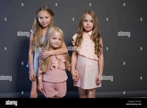 Three Beautiful Little Girls Sisters Portrait Fashion Grey Background
