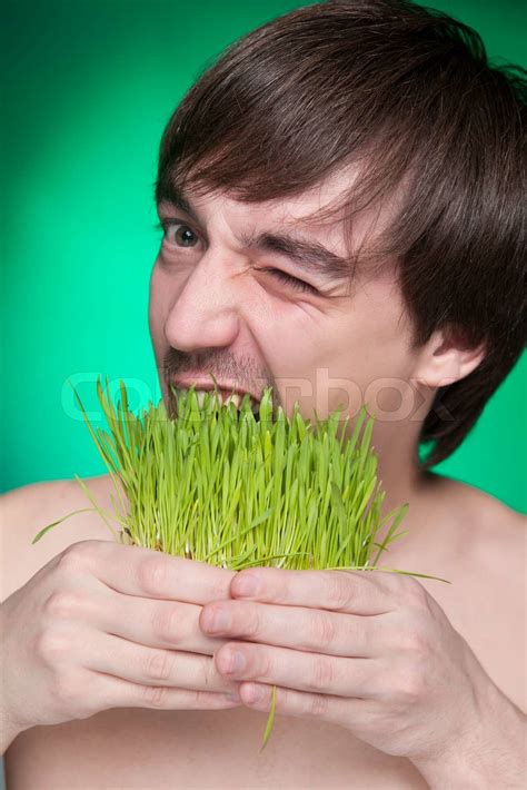 Young Man Eating A Bunch Of Fresh Green Grass Stock Image Colourbox