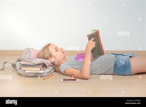 Schoolgirl Reading A Book In Classroom Stock Photo Alamy