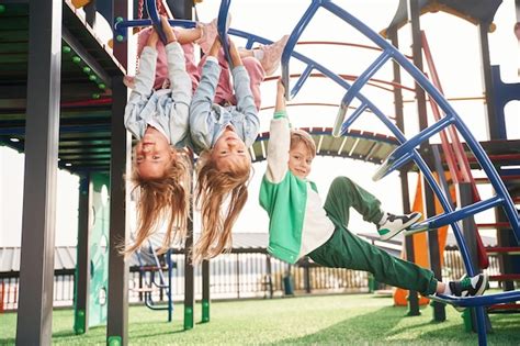 Premium Photo Hanging Upside Down Kids Are Having Fun On The Playground