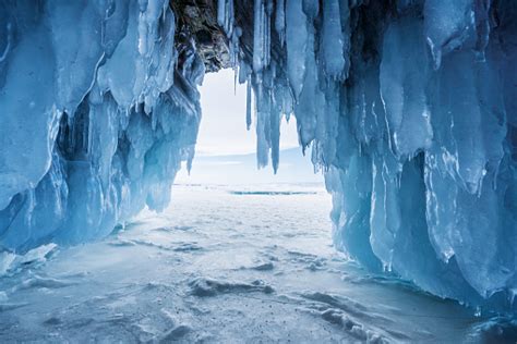 Winter Landscape Frozen Ice Cave With Bright Sunlight From Way Out At