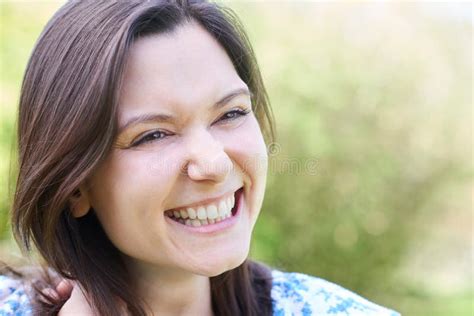 Outdoor Head And Shoulders Portrait Of Laughing Young Woman Stock Photo