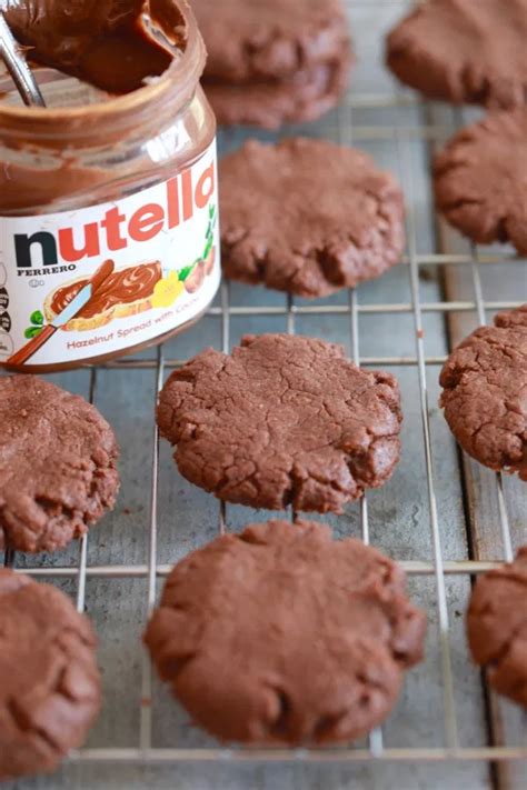 chocolate cookies cooling on a wire rack with a jar of nutella
