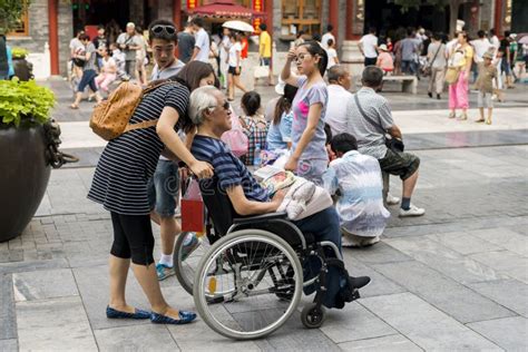 Old Man In A Wheelchair On Qianmen Street In Beijing Editorial
