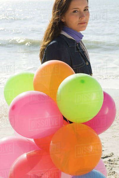 Preteen Girl With Bunch Of Balloons Walking On Beach Stock Photo Dissolve