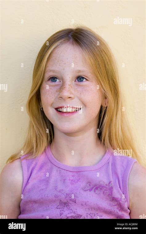 Portrait Of Blond Girl Age 9 With Blue Eyes And Freckles Smiling Stock