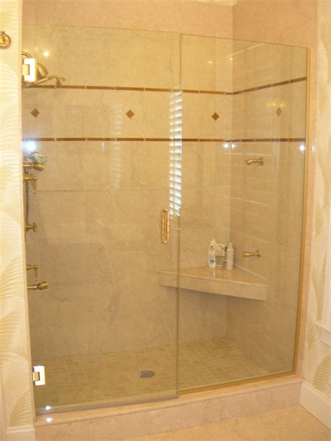 An Over Sized Shower Stall With A Corner Seat And Marble And Glass Tile Is A Luxury In This