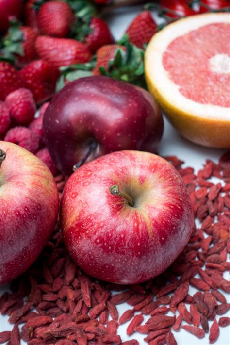 Zuerst müssen wir das bild in der folie einzufügen und dann das bild auswählen. Rote äpfel und anderes rotes obst und gemüse auf einem ...
