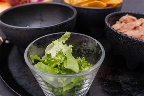 Bowls Of Chopped Lettuce Tortilla Chips And Refried Beans On Mexican