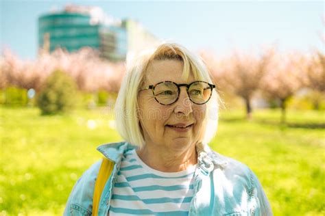 Closeup Portrait Of Blonde 50s Woman Wear Glasses In Amusement Park
