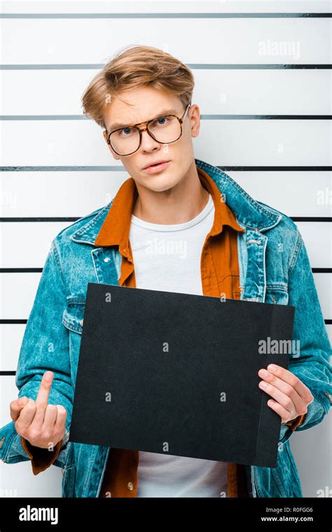 Handsome Young Man Holding Prison Board While Standing In Front Of