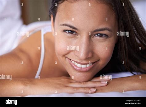 Happy That Its Finally Weekend Closeup Portrait Of A Beautiful Young Woman Lying On Her Bed