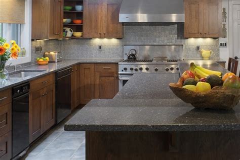 This white kitchen has a grey marble finish to the island, as well as globe pendant lights and marble grey mosaic tile backsplash. What are suitable cabinet colors for grey granite countertops?