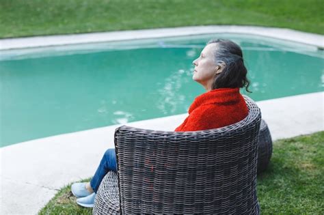 premium photo thoughtful senior caucasian woman sitting on chair by pool in garden retirement