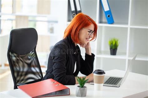 Young Happy Redhead Business Woman Sit Indoors In Office Using Laptop