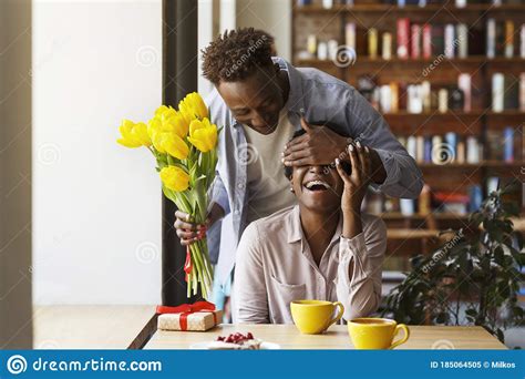 African American Guy Giving Flowers To His Girlfriend In Urban Cafe Stock Image Image Of