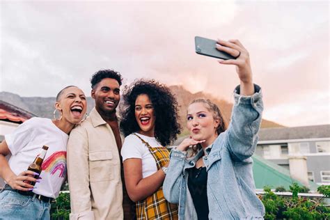 Friends Taking A Group Selfie Outdoors Four Happy Friends Posing For A