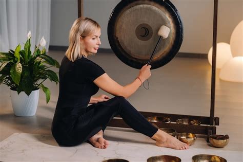 Premium Photo A Woman Knocks A Mallet With A Hammer On A Gong A Gong