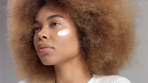 Mixed Race Black Woman With Big Afro Hair In Studio Put A Cream Smudge