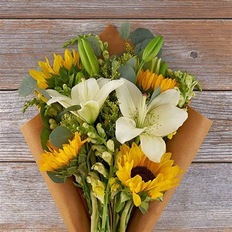 Sunflower Arrangement Featuring White Lilies And Solidago The Bouqs Co